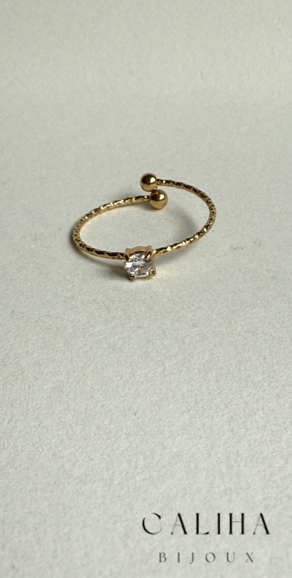 Bague dorée au style minimaliste, avec anneau lisse et une pierre brillante sertie au centre – Bijou élégant présenté sur fond neutre avec la marque CALIHA BIJOUX
