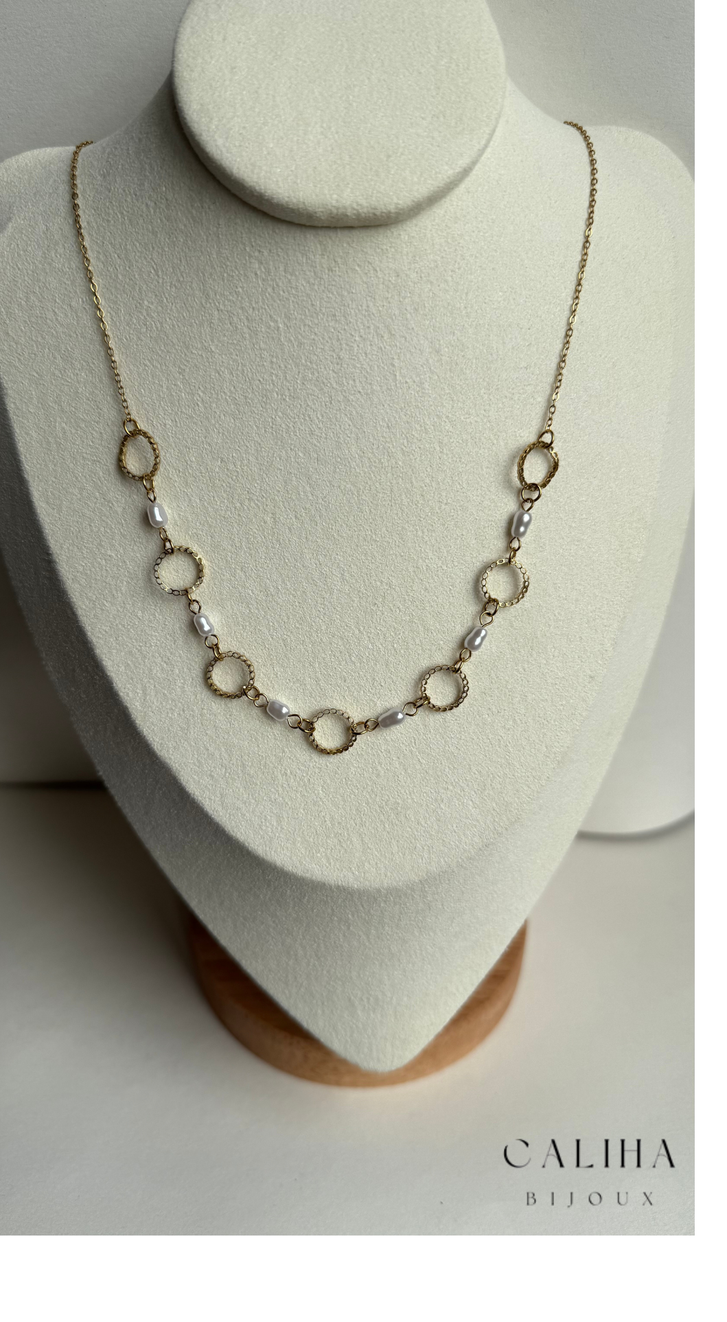 Collier en or avec alternance de maillons circulaires et de perles nacrées, posé sur un support blanc – Design intemporel et sophistiqué
