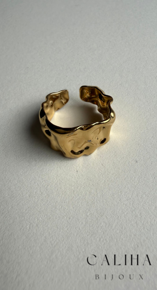 Bague dorée avec design irrégulier et texture organique, présentée sur fond nude avec la marque CALIHA BIJOUX – Bijou élégant et moderne 